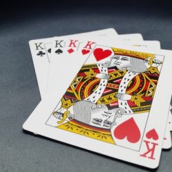 Kings play cards on fat green stools